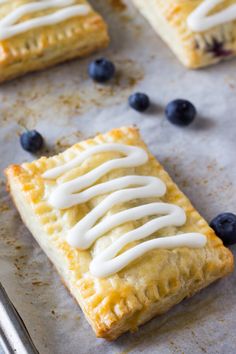 blueberry pastries with icing on a baking sheet