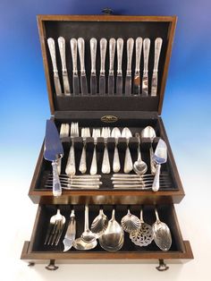 an assortment of silverware in a wooden case