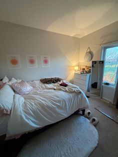 a bedroom with a bed, dresser and window