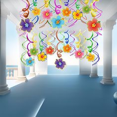 a room with columns and flowers hanging from it's ceiling in front of the ocean