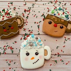 three decorated cookies sitting on top of a wooden table