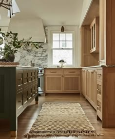 a kitchen with wooden cabinets and an area rug