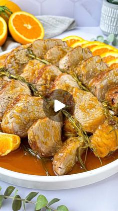 a plate with oranges and meat on it sitting next to some other food items