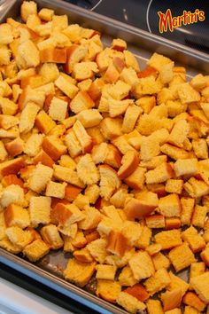 a pan filled with cubed bread sitting on top of a stove