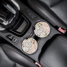 two cup holders in the center console of a car with colorful speckles on them