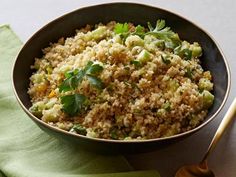 a bowl filled with rice and vegetables on top of a green napkin