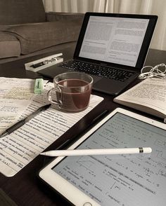 an open laptop computer sitting on top of a desk next to a cup of coffee