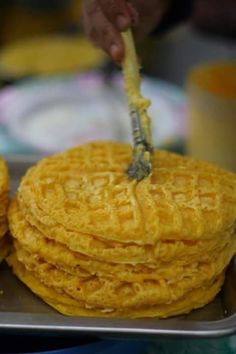 a stack of waffles on a metal tray with a fork sticking out of it