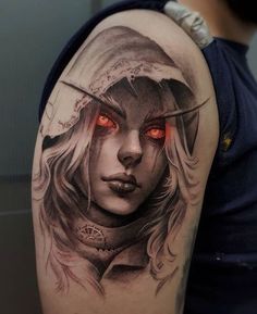 a woman with red eyes and a hood on her head is shown in this tattoo