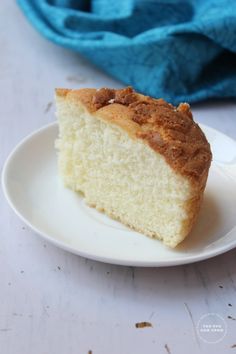 a piece of cake sitting on top of a white plate next to a blue towel