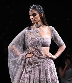 Editor's Note Step into bridal magnificence with our powder pink shimmer tulle silver crystal encrusted hand-embroidered lehenga set. The ensemble features a crystal and pearl sheeted choli, perfectly matched with an embroidered and cutwork edge shimmer tulle dupatta. This set is a celebration of opulence and tradition, ensuring you shine with elegance and allure on your special day. Fabric: Shimmer tulle Color: Pink Components: Lehenga, cancan skirt, blouse and 2 dupattas Occasion: Wedding Note Glamorous Organza Lehenga With Pearl Embroidery, Silver Lehenga With Pearl Embroidery For Reception, Glamorous Hand Embellished Organza Lehenga, Silver Embellished Organza Lehenga, Embellished Silver Organza Lehenga, Silver Hand Embellished Lehenga For Wedding, Silver Hand Embellished Wedding Lehenga, Wedding Silver Hand Embellished Lehenga, Cancan Skirt