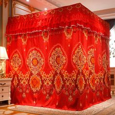 an elaborately decorated red bed spread in a room