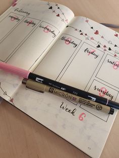 an open notebook with writing on it and a pink pen resting on the page next to it