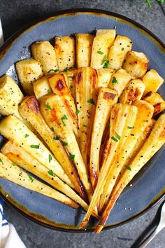 baked potato wedges on a blue plate with parsley sprinkled around them