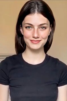 a woman is smiling and wearing a black shirt