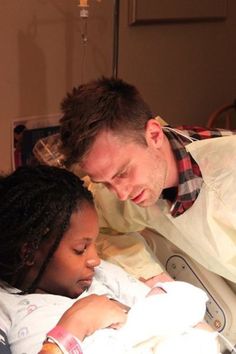 a man holding a baby in a hospital bed