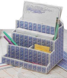 a blue and white desk organizer with pens, pencils, and markers in it