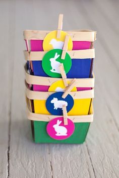 a stack of colorful wooden toy blocks with bunny tags attached to the handles and sides