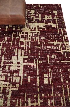 a brown leather chair sitting on top of a red and white rug next to a couch