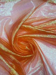 an orange and pink fabric with some gold foiling on the top, as well as other material