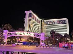 the mirage hotel and casino in las vegas is lit up with purple lights at night