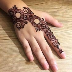 a woman's hand with henna tattoos on it