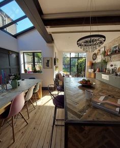 a dining room table with chairs and a bowl of fruit on it