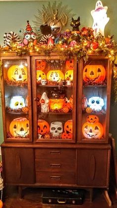 an old china cabinet decorated with pumpkins and jack - o'- lanterns