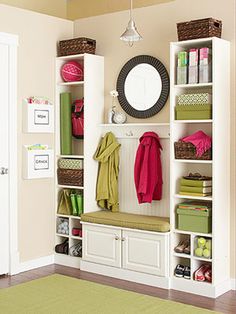 a white shelf filled with lots of clothes and other items next to a mirror on top of a wall