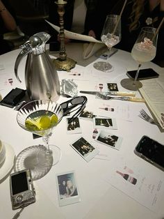 the table is cluttered with photos, wine glasses, and other personal items on it