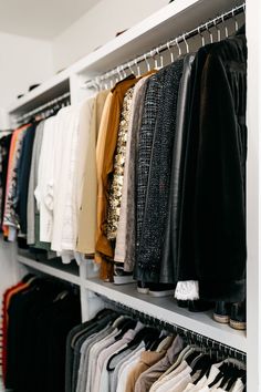 a closet filled with lots of clothes and pants hanging on the wall next to each other