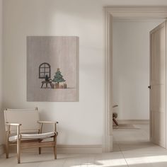 an empty room with a rocking chair and christmas tree on the wall in front of it