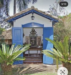 a small blue and white house with palm trees