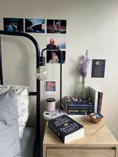 a bed room with a neatly made bed next to a night stand and pictures on the wall