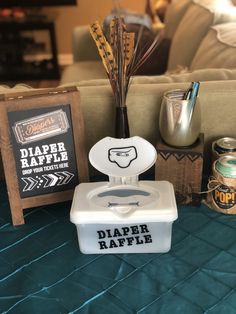 a diaper raffle box sitting on top of a bed next to other items