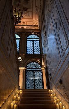 stairs leading up to an ornate window in a building with lit candles on the steps