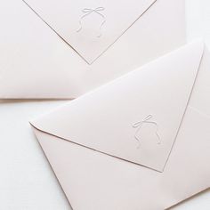 two envelopes with white paper on them