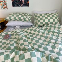 a green and white checkered comforter on a bed in a room with two nightstands