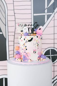 a birthday cake with sprinkles and decorations on it is displayed in front of a wall