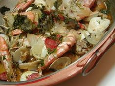 a pot filled with clams and shrimp on top of a table