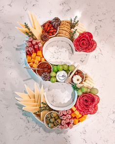 a number made out of cheese, crackers, fruit and other food on a table