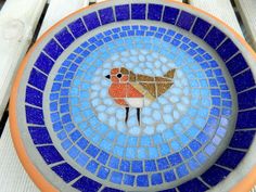 a blue and orange plate sitting on top of a wooden table next to a bench