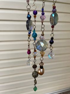 a wind chime with many different colored beads hanging from it's chain,