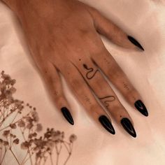 a woman's hand with black nail polish on it and the word love written in cursive writing