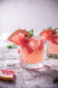 two glasses filled with pink lemonade and garnish