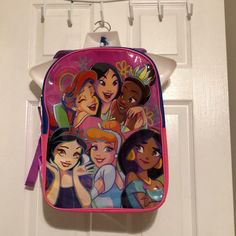 a pink backpack with princesses on it hanging from a hook