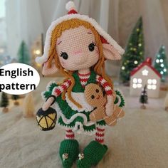 a knitted doll holding a teddy bear and wearing a santa claus hat with the words english pattern above it