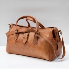 Elevate your travel game with our meticulously crafted Moroccan Leather Weekend Bag. Handcrafted from 100% premium leather, this bag seamlessly combines elegance with durability. Its spacious interior is designed to accommodate all your essentials, while a dedicated shoe pocket keeps your footwear separate and organised. Perfect for weekend getaways, this stylish bag ensures you travel with both sophistication and convenience. Experience the exceptional quality and timeless charm of Moroccan cra Leather Weekender Bag, Leather Weekender, Moroccan Leather, Travel Games, Weekend Bag, Travel Duffel, Duffel Bag Travel, Top Grain Leather, Stylish Bag