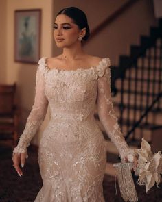 a woman in a wedding dress is walking down the stairs with her hands on her hips