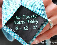 a close up of a person holding a tie with a wedding date written on it